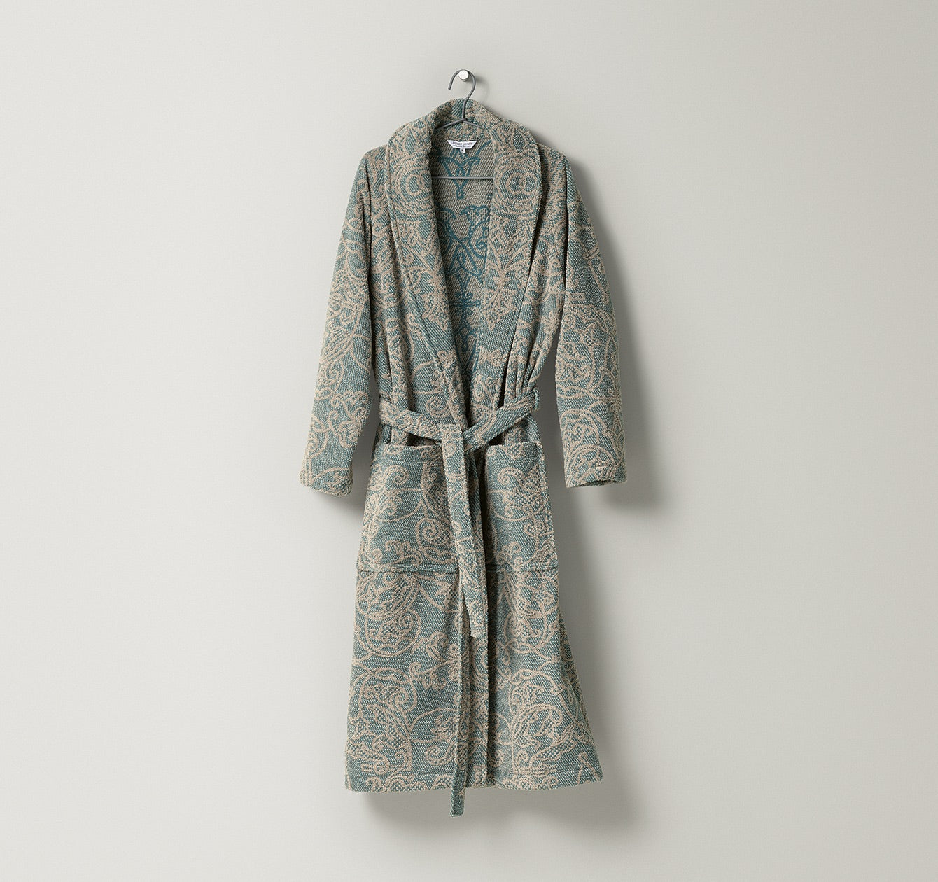 Bademantel Mariage aus Frottier mit dekorativem, ornamentalem Muster in natürlichen Beige- und Graugrüntönen, gefertigt aus Leinen und Baumwolle – edler Wohlfühlmantel von Leitner Leinen bei Rivera Interiors.

