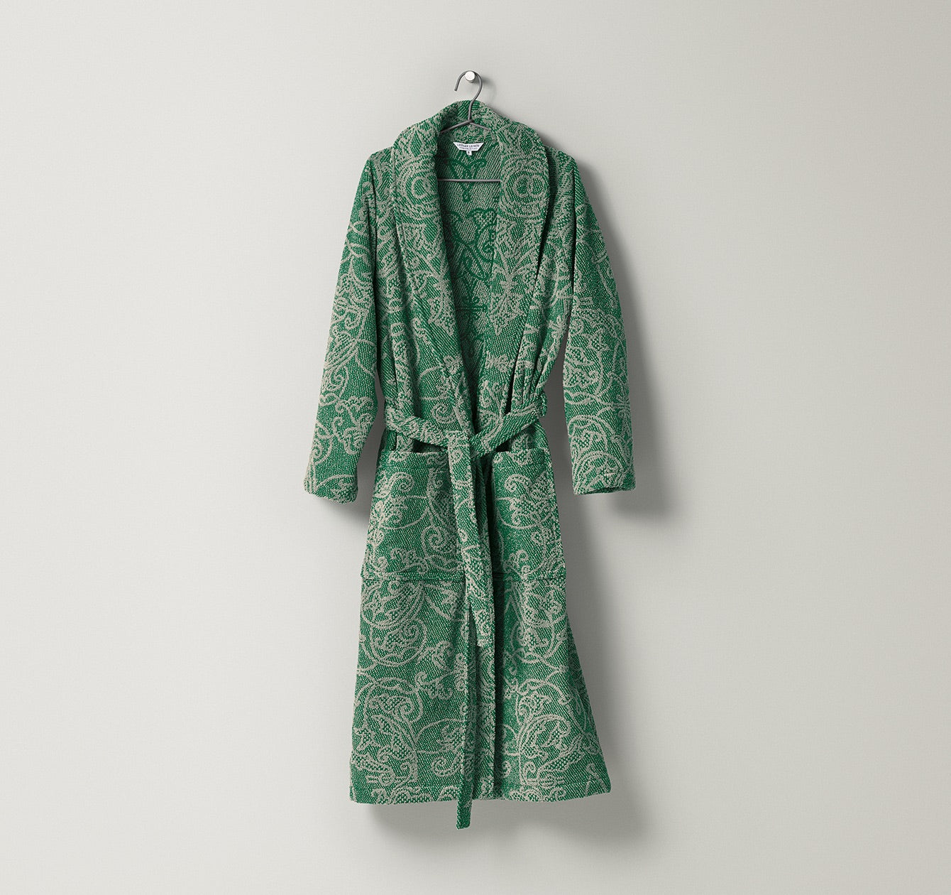 Bademantel Mariage aus Frottier mit dekorativem, ornamentalem Muster in natürlichen Sand- und Grüntönen, gefertigt aus Leinen und Baumwolle – edler Wohlfühlmantel von Leitner Leinen bei Rivera Interiors.

