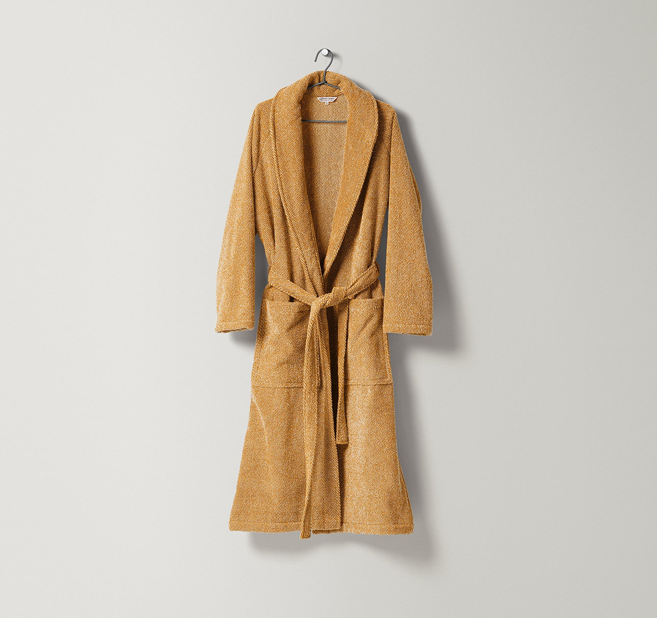 Unisex-Bademantel Uni aus Frottier mit natürlicher Struktur und zweifarbigem Gewebe in warmem Sand und Honiggelbton gefertigt aus Leinen und Baumwolle, erhältlich bei Rivera Interiors.

